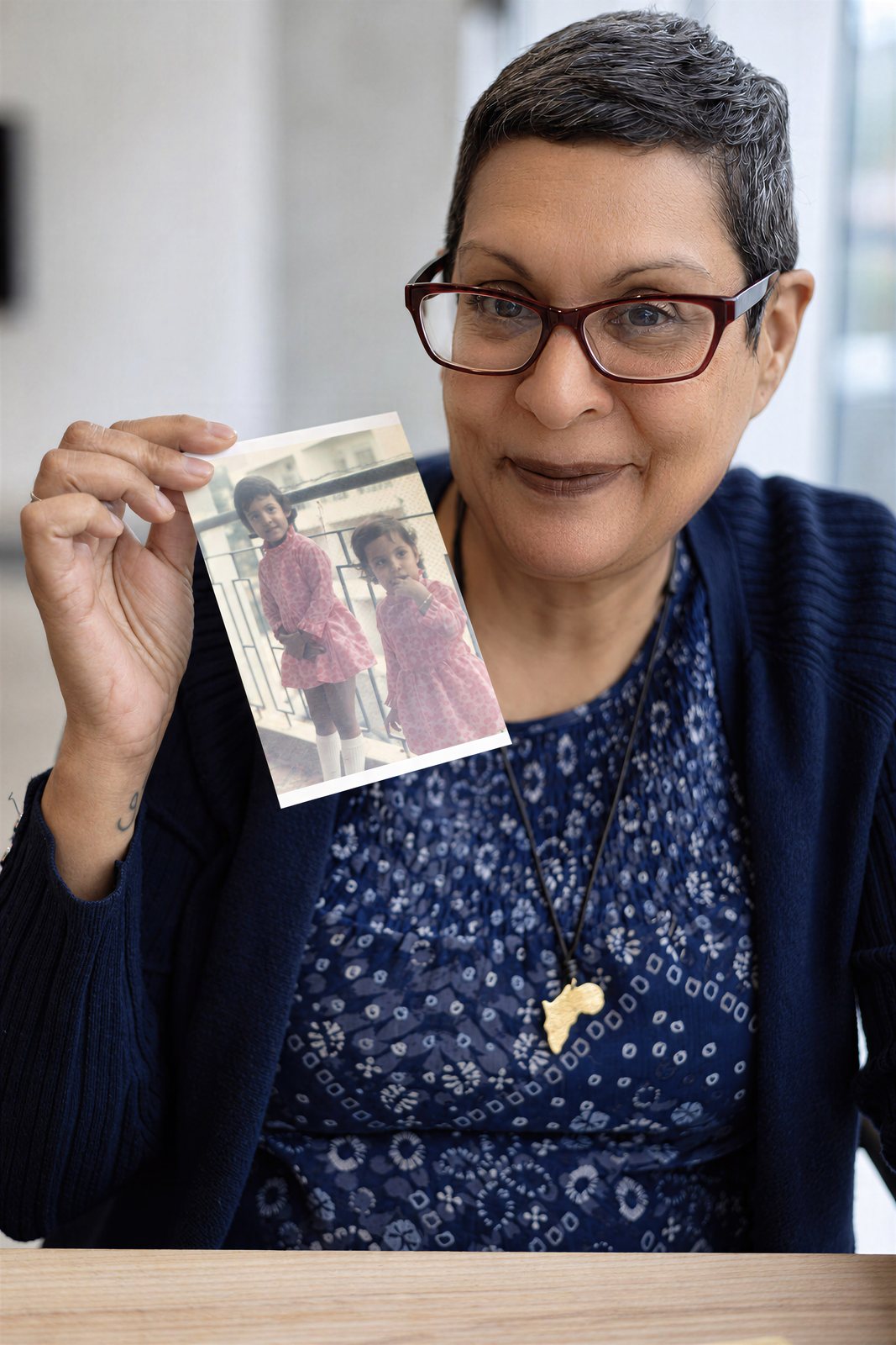 Amina holds up an old family photograph, a link to the Uganda her family was forced to leave in 1972.