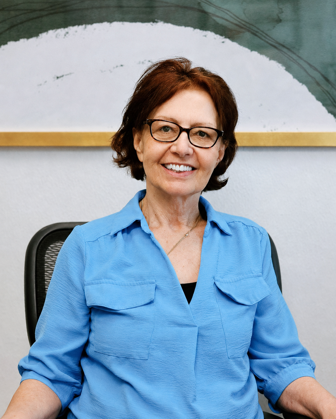 Portrait of Olga in her office beneath a large painting