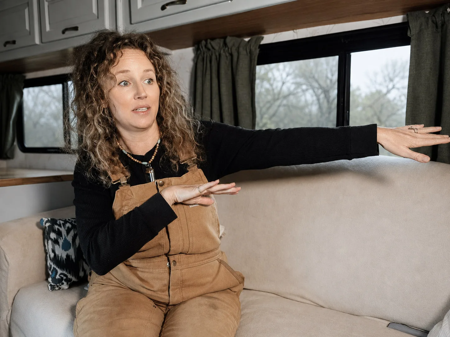 Kristen Kelly gestures with both arms while talking during a field interview in Storyville, Texas